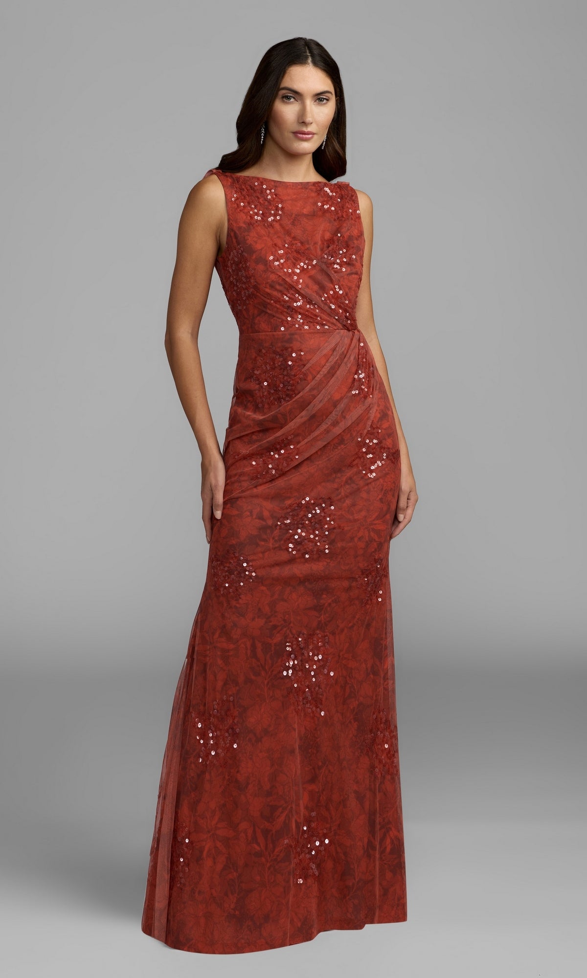 A woman poses against a plain gray background in the Mac Duggal 94263 Cowl-Back Floral Formal Gown—a sleeveless, floor-length red dress adorned with sequin embellishments and subtle floral patterns—offering an elegant choice for any special occasion.